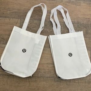 Two white lululemon shopping bags